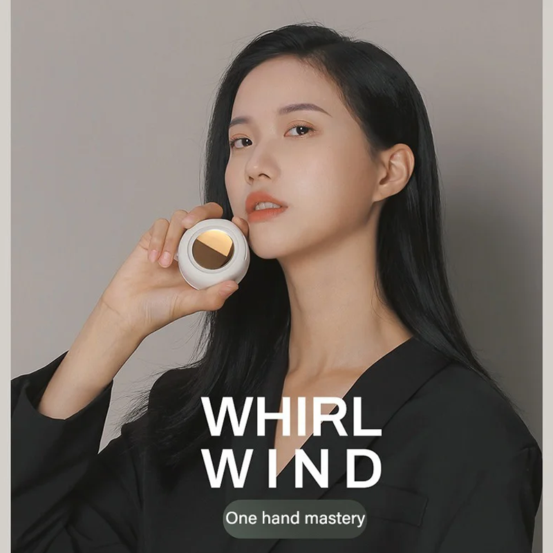 Mujer sosteniendo un mini ventilador portátil de color blanco cerca de su mejilla.